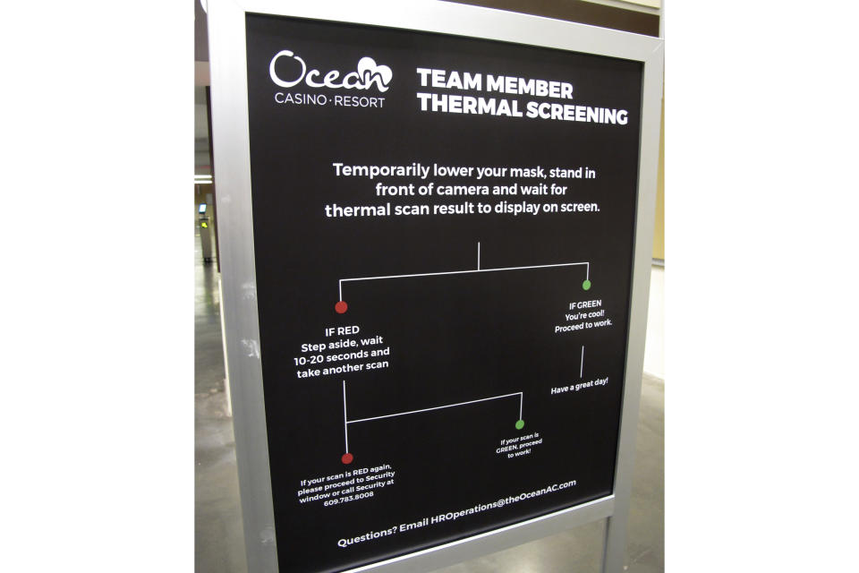 A sign directs employees in how to have their body temperature scanned sits in a walkway of the Ocean Casino Resort on June 3, 2020, about a month before it reopened during the early days of the COVID19 pandemic. On Jan. 24, 2024, the New Jersey Supreme Court rejected an attempt by the casino to collect on a business interruption policy for the 3 1/2 months it was closed due to the pandemic. (AP Photo/Wayne Parry)