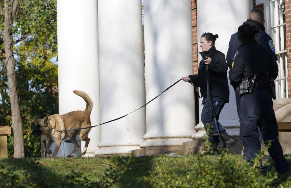 A Virginia Department of Corrections canine team searches the scene near an overnight shooting that occurred at the University of Virginia, Monday, Nov. 14, 2022, in Charlottesville. Va. (AP Photo/Steve Helber)