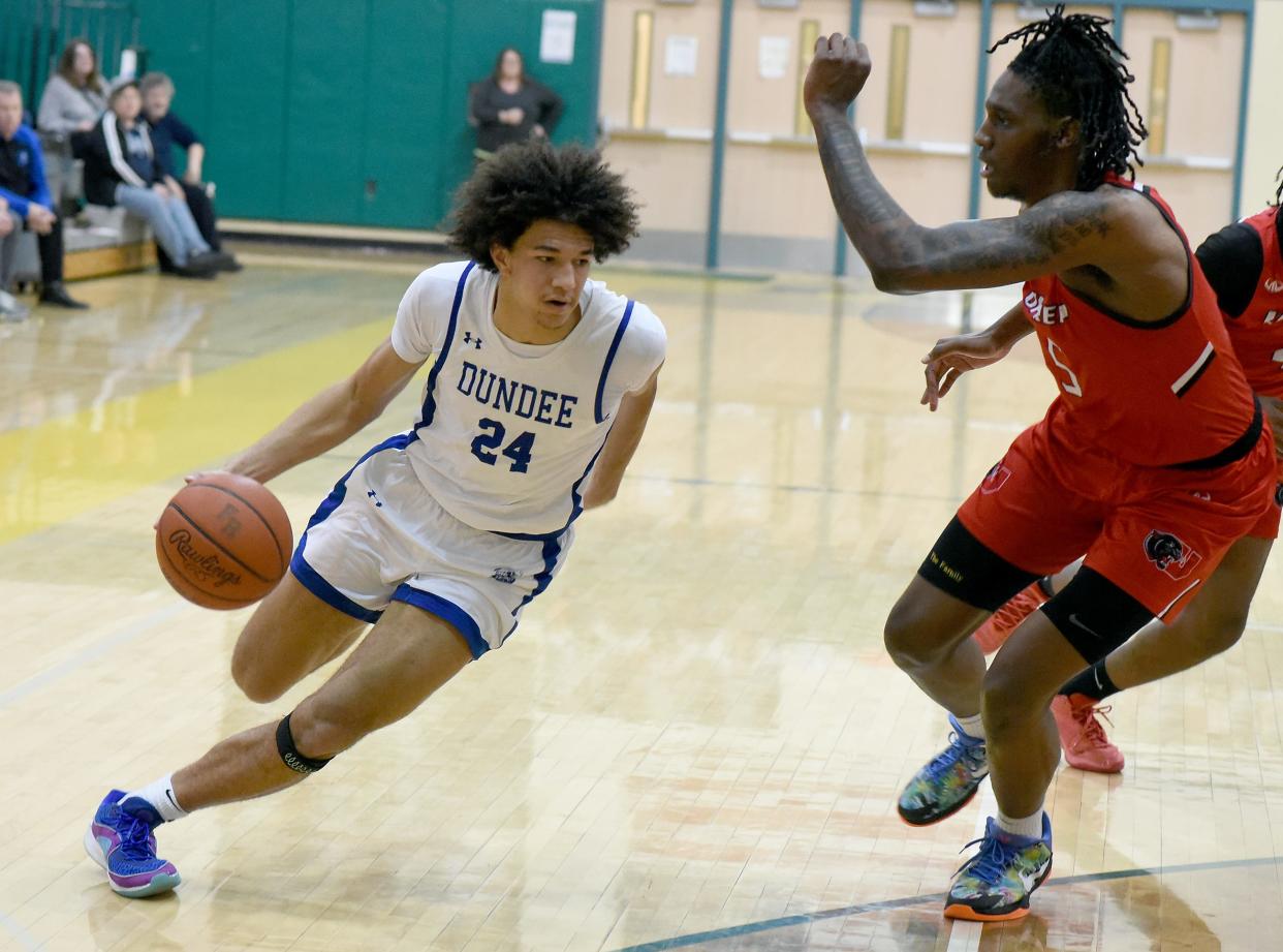 Braiden Whitaker of Dundee drives on Xander Wedlow, of University Prep Academy to the hoop in the Division 2 Regional Final at Flat Rock High School Thursday, March 7, 2024. The Dundee Vikings lost the game 52-43.