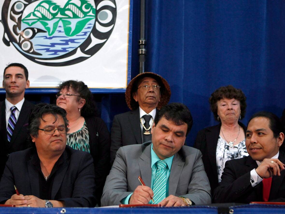 Beecher Bay (SC’IA⁄NEW) First Nation Chief Russ Chipps, representing one of five Te'mexw Treaty Association members, signs an agreement-in-principle towards final treaties in 2015. Those treaties are now in the final negotiation stage, and the public is invited to lean more at a series of open houses.  (The Canadian Press - image credit)