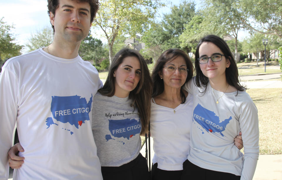 Wearing T-shirts with the message "Free the Citgo 6," the Vadell family poses for a photo in Katy, Texas, Friday, Feb. 15, 2019. From left are Hayes Weggeman, his wife Veronica Vadell, his mother-in-law Dennysse Vadell and sister-in-law Cristina Vadell. Dennysse's husband and her daughter's father Tomeu, a Citgo executive, has spent 15 months jailed in Venezuela along with five other Citgo executives on what their families say are trumped-up corruption charges. (AP Photo/John L Mone)