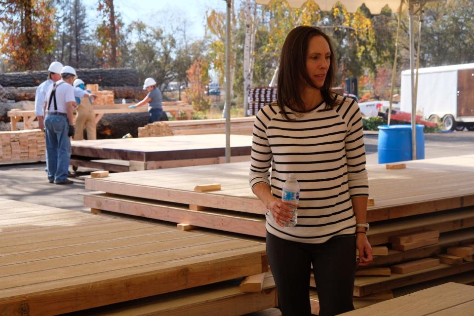 Joelle Chinnock, secretary of Love Paradise, checks in with volunteers building sheds for Camp Fire survivors in November 2019 in Paradise, California.