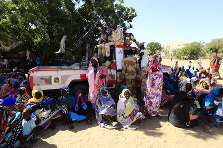 Women sit near a vehicle of the special police forces after it arrived in Tabit village in North Darfur November 20, 2014. REUTERS/Mohamed Nureldin Abdallah