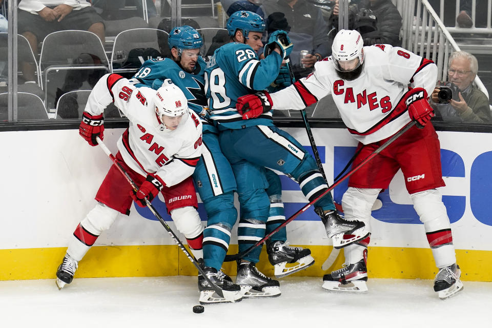 Carolina Hurricanes left wing Teuvo Teravainen (86) and defenseman Brent Burns (8) collide with San Jose Sharks center Tomas Hertl (48) and right wing Timo Meier (28) during the third period of an NHL hockey game in San Jose, Calif., Friday, Oct. 14, 2022. (AP Photo/Godofredo A. Vásquez)