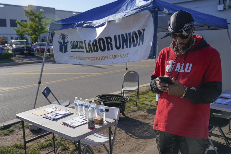 Chris Smalls, president of the Amazon Labor Union, sets up an information booth to collect signatures across the street from an Amazon distribution center in the Staten Island borough of New York, Thursday, Oct. 21, 2021. A bid to unionize Amazon workers at the distribution center in New York City neared an important milestone, as organizers prepared to deliver hundreds of signatures to the National Labor Relations Board as soon as Monday for authorization to hold a vote. (AP Photo/Seth Wenig)