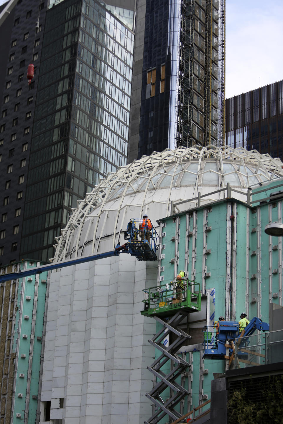 Workers install marble on the exterior of St. Nicholas Greek Orthodox Church and National Shrine, the only house of worship on ground zero, on Thursday, July 22, 2021, in New York. Through an innovative process, interior lights are being designed to illuminate thin panels of marble mined from the same Pentelic vein in Greece that sourced the Parthenon, the ancient temple in Athens. The shrine will have a ceremonial lighting on the eve of the 20th anniversary of the Sept. 11, 2001 attacks, while the interior is slated for completion next year. (AP Photo/Jessie Wardarski)