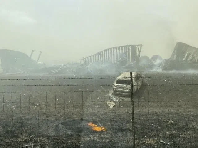 Smoldering wreckage is seen after a crash involving at least 20 vehicles shut down a highway in Illinois, Monday, May 1, 2023. Illinois State Police say a windstorm that kicked up clouds of dust in south-central Illinois led to numerous crashes and multiple fatalities on Interstate 55. (WICS TV via AP)