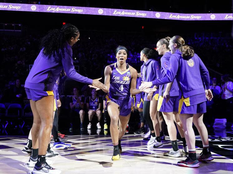 The Sparks' Lexie Brown is cheered by teammates as she is introduced before a preseason game