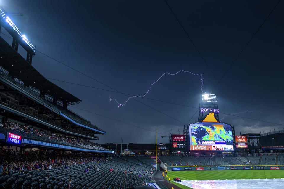 Lightning strikes behind the scoreboard at Coors Field during a rain delay before a baseball game between the Cincinnati Reds and the Colorado Rockies on July 13, 2019 in Denver, Colorado. / Credit: JULIO AGUILAR / Getty Images