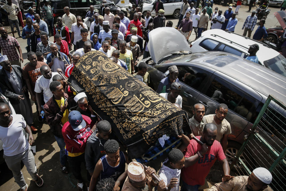 Relatives carry the body of 13-year-old Yasin Hussein Moyo for burial, at the Kariakor cemetery in Nairobi, Kenya Tuesday, March 31, 2020. The family of a 13-year-old boy is in mourning after police in Kenya's capital are accused of shooting him dead while enforcing a coronavirus curfew. Kenya’s police inspector general has ordered an investigation into the boy’s death by “stray bullet,” including a forensic analysis of all firearms held by officers at the scene. (AP Photo/Brian Inganga)