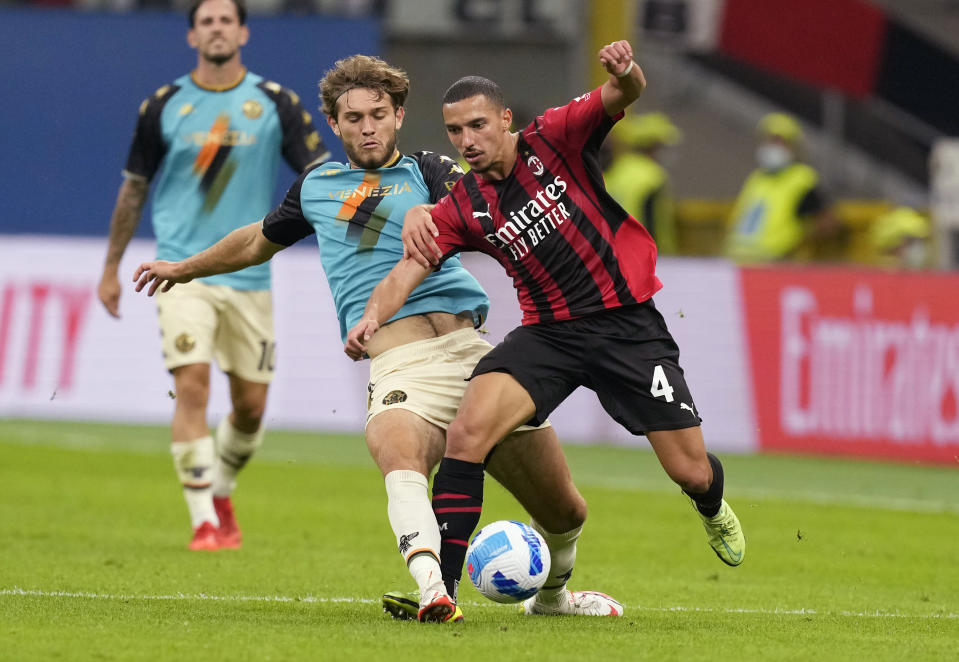 Venezia's Tanner Tessmann, left, challenges for the ball with AC Milan's Ismael Bennacer during the Serie A soccer match between AC Milan and Venezia at the San Siro stadium, in Milan, Italy, Wednesday, Sept. 22, 2021. Italian soccer team Venezia is back in the top division for the first time since 2002. And it has tapped Major League Soccer to recruit young Americans in its bid to stay afloat in Serie A. Nineteen-year-old Gianluca Busio arrived in Venice from Sporting Kansas City and 20-year-old Tanner Tessmann from FC Dallas. (AP Photo/Antonio Calanni)