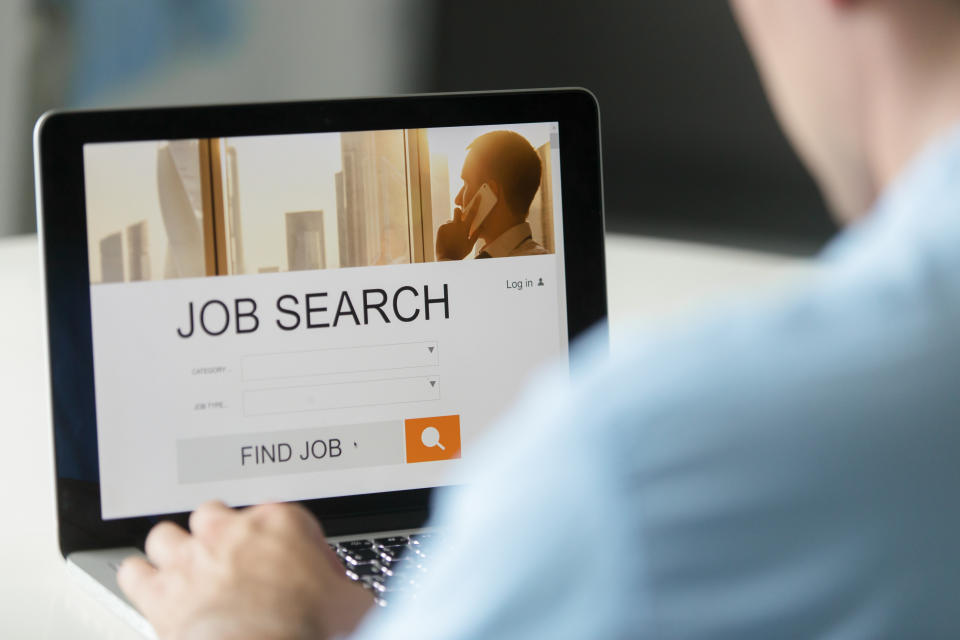 Monitor view over a male shoulder, job search title on the screen, close up. 