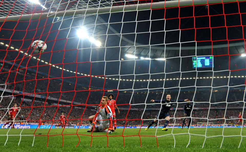Manchester United's Wayne Rooney, right, celebrates his side's first goal scored by his teammate Patrice Evra during the Champions League quarterfinal second leg soccer match between Bayern Munich and Manchester United in the Allianz Arena in Munich, Germany, Wednesday, April 9, 2014. Munich defeated Manchester by 3-1. (AP Photo/Kerstin Joensson)