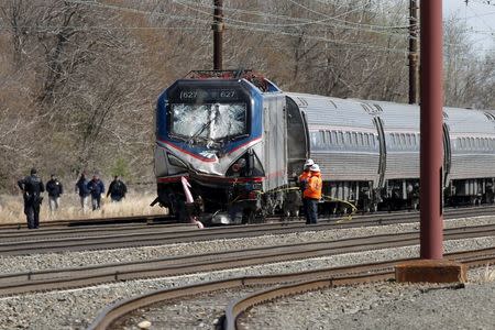 Emergency personnel examine the scene after an Amtrak passenger train struck a backhoe, killing two people, in Chester, Pennsylvania, April 3, 2016. REUTERS/Dominick Reuter