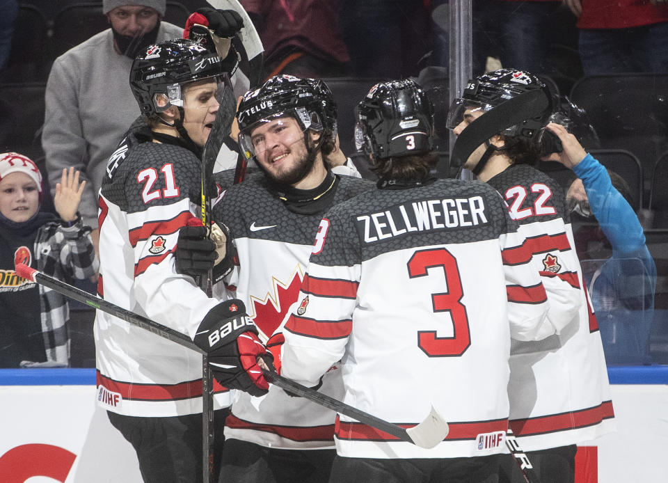 Canada's Kaiden Guhle (21), Mason McTavish (23), Olen Zellweger (3) and Mavrik Bourque (22) celebrate a goal against the Czech Republic during first-period IIHF world junior hockey championship game action in Edmonton, Alberta, Sunday, Dec. 26, 2021. (Jason Franson/The Canadian Press via AP)