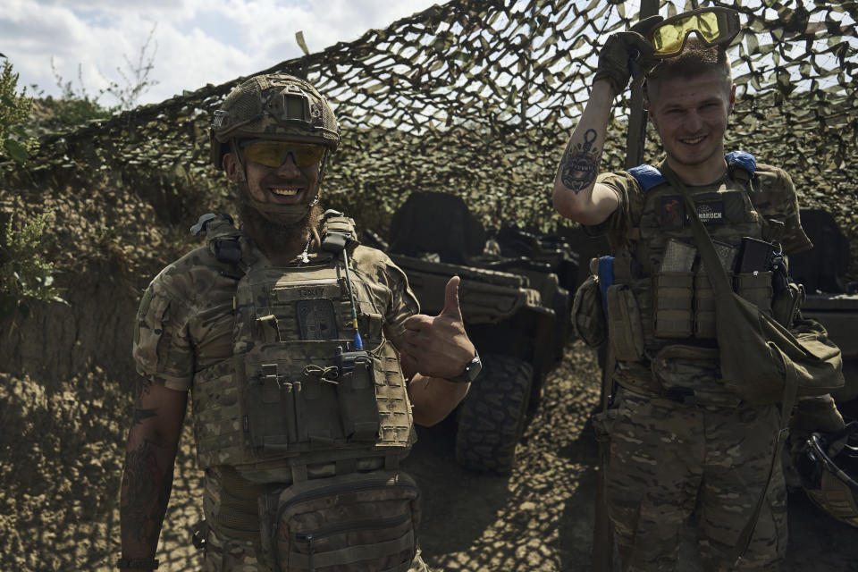 Soldiers of Ukraine's 3rd Separate Assault Brigade share a joke as they stand on their position near Bakhmut, the site of fierce battles with the Russian forces in the Donetsk region, Ukraine, Sunday, Sept. 3, 2023. (AP Photo/Libkos)