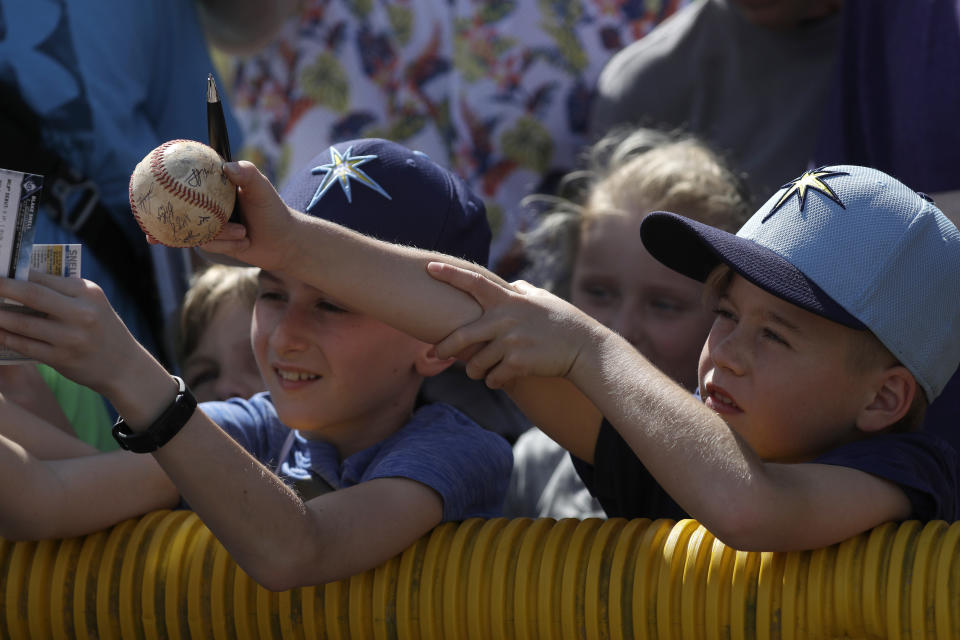 Young Tampa Bay Rays fans reach for autographs during spring training baseball camp Monday, Feb. 17, 2020, in Port Charlotte, Fla. (AP Photo/John Bazemore)