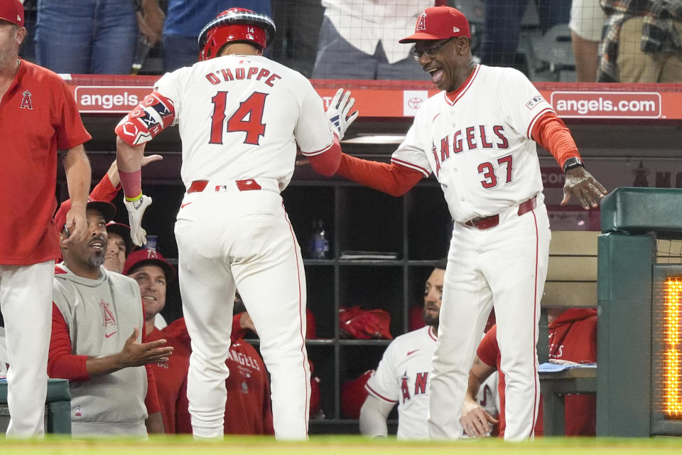 Los Angeles Angels' Logan O'Hoppe (14) celebrates his go-ahead three-run home run with manager Ron Washington (37) during the eighth inning of the team's baseball game against the Detroit Tigers, Friday, June 28, 2024, in Anaheim, Calif. (AP Photo/Ryan Sun)