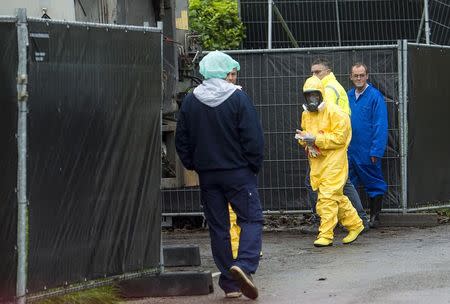 An expert wearing a protection suit arrives at a poultry farm, where a highly contagious strain of bird flu was found by Dutch authorities, in Hekendorp November 17, 2014. REUTERS/Marco De Swart