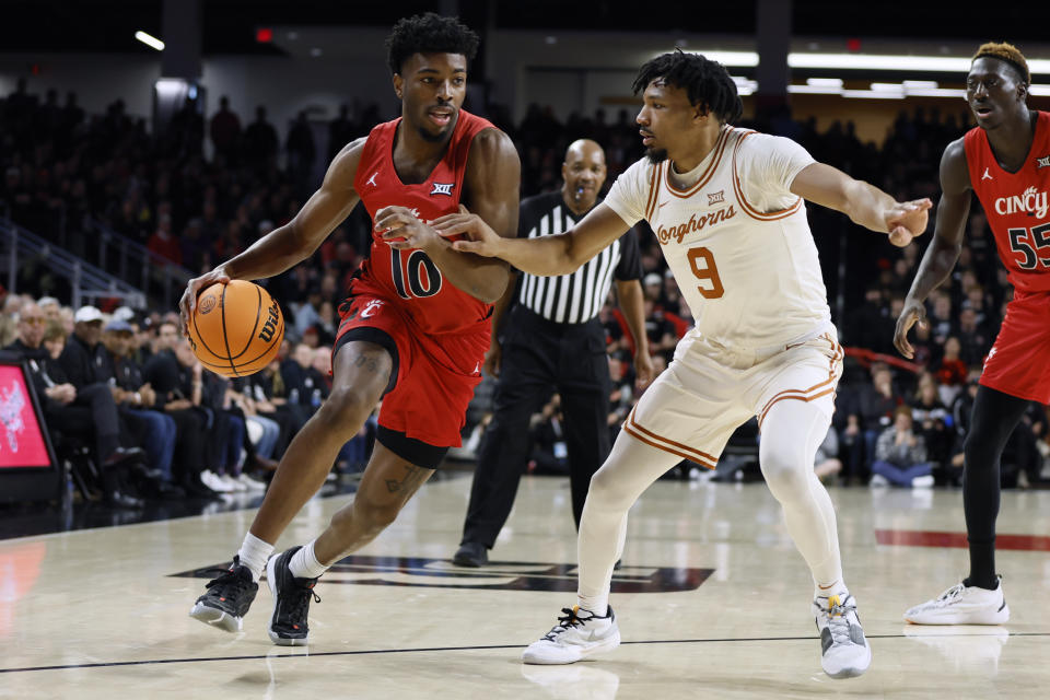 Cincinnati's Josh Reed, left, drives to the basket against Texas' Ithiel Horton during the first half of an NCAA college basketball game Tuesday, Jan. 9, 2024, in Cincinnati. (AP Photo/Jay LaPrete)