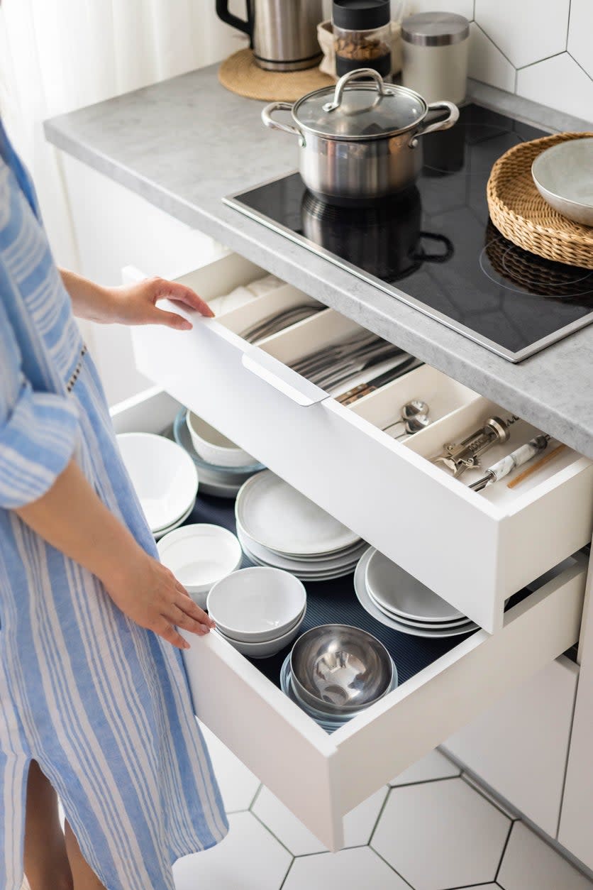 woman pulling out drawers in the kitchen