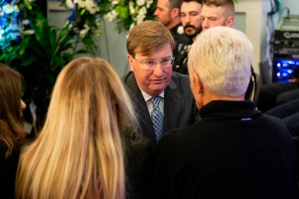 Gov. Tate Reeves presents a folded Mississippi state flag to the family of fallen officer Branden Estorffe during the funeral for Bay St. Louis police officers Sgt. Steven Robin and Branden Estorffe at the Bay St. Louis Community Center in Bay St. Louis on Wednesday, Dec. 21, 2022. Robin and Estorffe were killed responding to a call at a Motel 6 on Dec. 14.