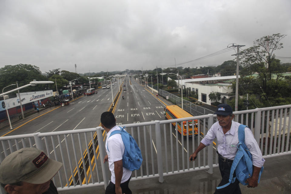 Hombres cruzan una carretera con poca circulación debido a una huelga general convocada por la oposición al presidente nicaragüense, Daniel Ortega, en Managua, Nicaragua, el jueves 23 de mayo de 2019. (AP Foto / Alfredo Zuniga)