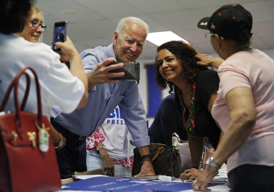 FILE - In this July 20, 2019, file photo, former Vice President and Democratic presidential candidate Joe Biden takes a selfie with a supporter during a campaign event at an electrical workers union hall in Las Vegas. More than traditional markers of electability like name recognition, fundraising ability or charisma, the path to the Democratic nomination runs through black voters. (AP Photo/John Locher, File)