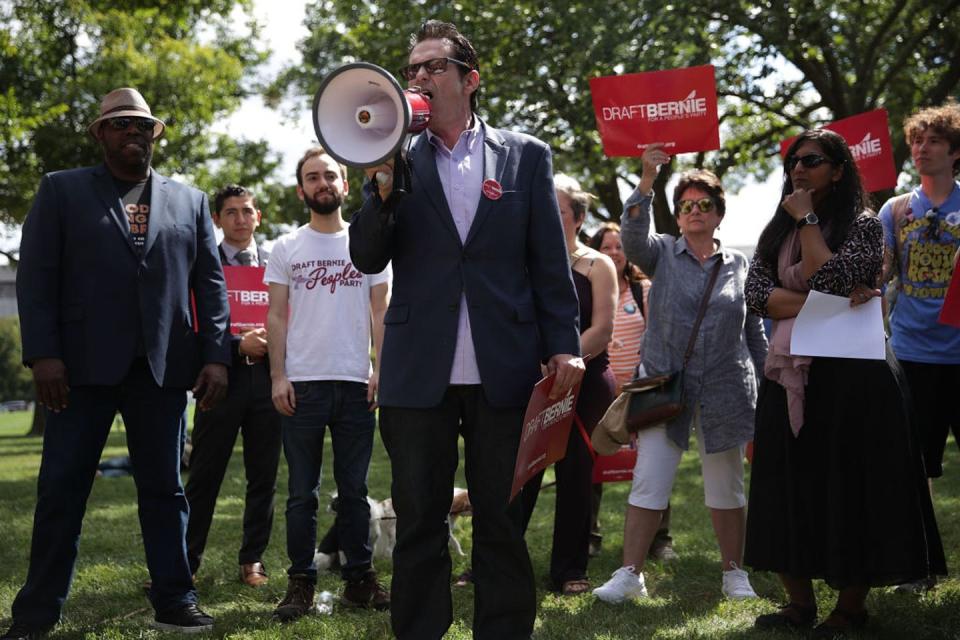 <span class="caption">Jimmy Dore, speaking into a megaphone, hosts his popular political talk show from his garage.</span> <span class="attribution"><a class="link " href="https://www.gettyimages.com/detail/news-photo/comedian-and-host-of-the-jimmy-dore-show-jimmy-dore-speaks-news-photo/844361332?adppopup=true" rel="nofollow noopener" target="_blank" data-ylk="slk:Alex Wong/Getty Images;elm:context_link;itc:0;sec:content-canvas">Alex Wong/Getty Images</a></span>