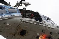 A law enforcement officer with a rifle sits in a helicopter above the scene of a shooting at the Washington Navy Yard in Washington, September 16, 2013. (REUTERS/Jonathan Ernst)