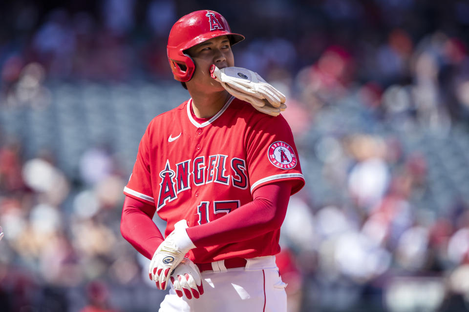 Los Angeles Angels designated hitter Shohei Ohtani changes out his hitting gloves for base-running gloves while on first base during the third inning of a baseball game against the Seattle Mariners in Anaheim, Calif., Sunday, Sept. 18, 2022. (AP Photo/Alex Gallardo)