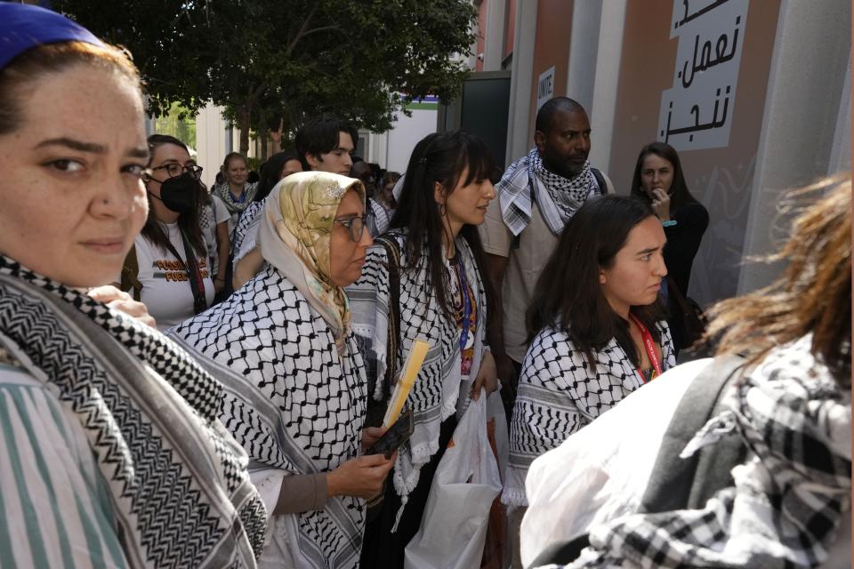 Pro-Palestinian activists wearing keffiyehs stand outside ahead of a session on food security put on by the Heschel Center for Sustainability, an Israeli organization, at the COP28 U.N. Climate Summit, Saturday, Dec. 9, 2023, in Dubai, United Arab Emirates. The session was canceled. (AP Photo/Peter Dejong)