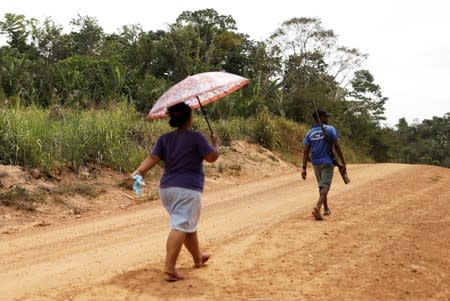 A man and his wife walk on dirt road at Esperanca PDS, a Sustainable Settlement Project, in Anapu