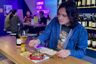 A customer eats tinned fish at the DECANTsf bar, Friday, Oct. 13, 2023, in San Francisco. (AP Photo/Haven Daley)