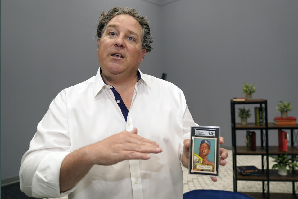 Chris Ivy, Heritage Auctions Director of Sports Auctions, holds and talks about a Mickey Mantle baseball card at in Dallas, Thursday, July 21, 2022. The mint-condition Mantle card is expected to sell well into the millions when bidding ends at the end of the month. (AP Photo/LM Otero)