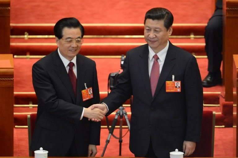 Newly-elected Chinese President Xi Jinping (R) holds hands with former president Hu Jintao at the National People's Congress (NPC) in the Great Hall of the People in Beijing on March 14, 2013. China's parliament named Xi as president, four months after he took charge of the Communist Party with pledges of reform that have raised hopes but so far yielded little change