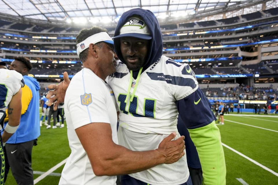 The Seahawks' DK Metcalf hugs Chargers wide receivers coach Sanjay Lal, the receiver's former coach in Seattle.