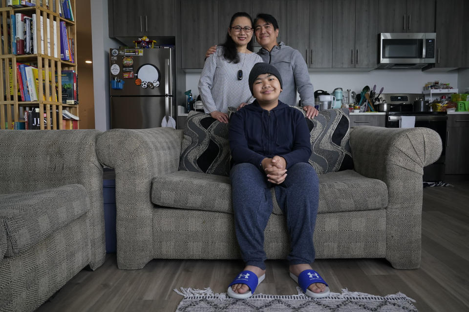 Jefferson Union High School District math teacher Eleonor Obedoza, her husband Arman and son Angelo, 12, pose for a photograph inside their new three-bedroom apartment in Daly City, Calif., Friday, July 8, 2022. The school district in San Mateo County is among just a handful of places in the country with educator housing. But with a national teacher shortage and rapidly rising rents, the working class district could serve as a harbinger as schools across the U.S. seek to attract and retain educators. (AP Photo/Godofredo A. Vásquez)