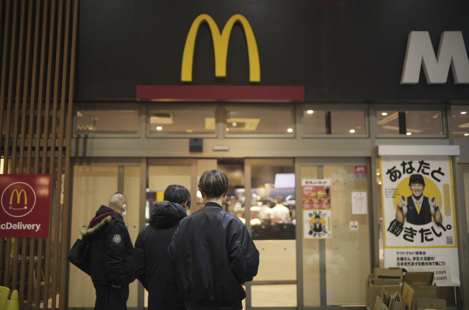 People look at a sign outside a McDonald's store, which notified it has closed earlier than usual due to "system error," in Tokyo, Friday, March 15, 2024. (AP Photo/Hiro Komae)