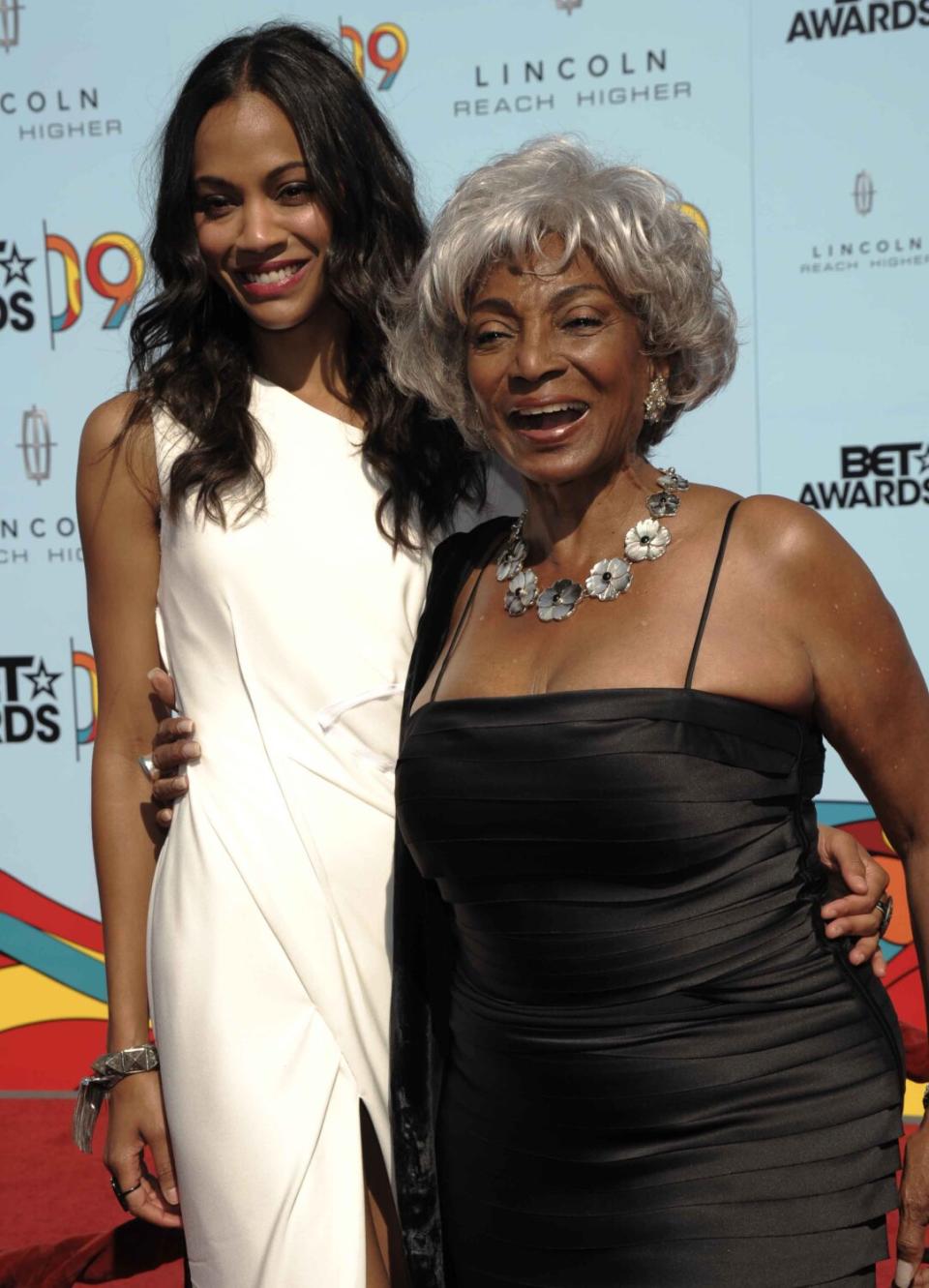 A woman in a white dress posing with a woman in a black dress