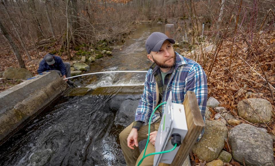 State fisheries biologist Patrick McGee and other researchers prepare to track the spring return of spawning river herring by installing antennae on fish ladders along the Saugatucket River.