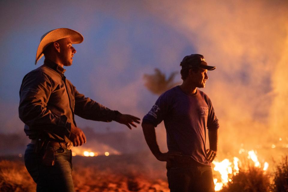 A laborer with a friend looks at a fire that spread to the farm he works on next to a highway in Nova Santa Helena municipality in northern Mato Grosso State, south in the Amazon basin in Brazil, on Aug. 23, 2019. (Photo: Joao Laet/AFP/Getty Images)