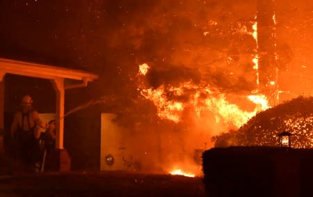 Firefighters battle a wind-driven wildfire called the Saddle Ridge fire in the early morning hours Friday in Porter Ranch