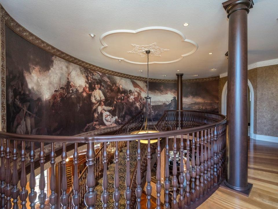 At the top of the floating staircase is a reproduction of a revolutionary war painting "The Battle of Bunker Hill" by John Trumbull