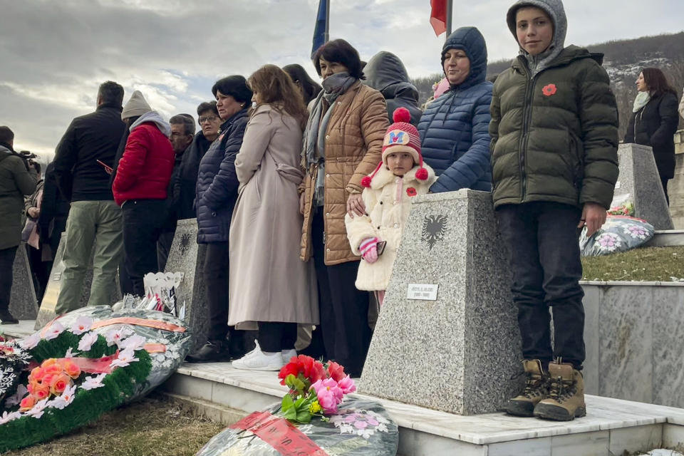 People observe a moment of silence at a memorial for Kosovars killed in 1999 by Serb forces in Recak, Kosovo, Monday, Jan. 15, 2024. Hundreds of Kosovars have gathered in a southern village to commemorate the 25th anniversary of the mass killing of 45 ethnic Albanians by Serb forces which was a decisive moment to spark international anger and prompt a 78-day U.S. and NATO air campaign to end Kosovo's 1998-99 war.(AP Photo/Zenel Zhinipotoku)