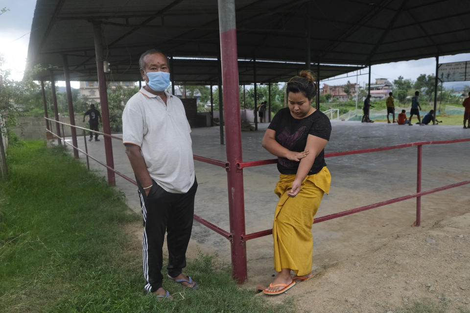 Diana Khumanthem, 30, stands beside her father Yaima Khumanthem, 75, in a public gathering space where Yaima chooses to spend his day after his wife and daughter died of COVID-19, in Imphal, in Manipur, India, Monday, June 28, 2021. Life is tentatively returning to normal in India as coronavirus cases fall. But millions are embroiled in a nightmare of huge piles of medical bills. Most Indians don’t have health insurance and costs for COVID-19 treatment have them drowning in debt. (AP Photo/Yirmiyan Arthur)