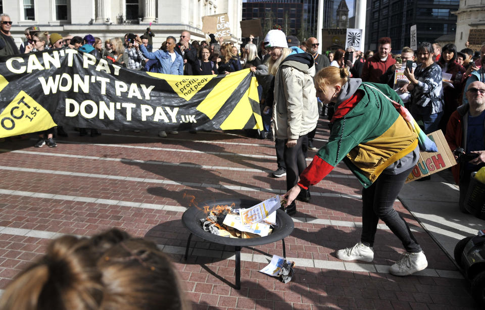 FILE- Protesters burn symbolic energy bills outside the ICC in Birmingham prior to the Conservative Party conference at the ICC, Birmingham, England, Oct. 1, 2022. Across Europe, soaring inflation is behind a wave of protests and strikes that underscores growing discontent with spiralling living costs and threatens to unleash political turmoil. (AP Photo/Rui Vieira, file)