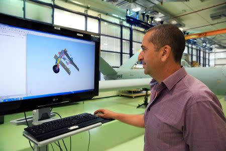 An employee looks at a computer screen as he stands next to an Elbit Systems Ltd. Hermes 900 unmanned aerial vehicle (UAV) at the company's drone factory in Rehovot, Israel, June 28, 2018. REUTERS/Orel Cohen