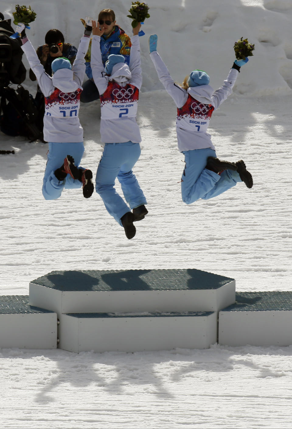 From left, bronze medalist Norway's Kristin Stoermer Steira, gold medalist Norway's Marit Bjoergen and silver medalist Norway's Therese Johaug jump in celebration during the flowers ceremony for the women's 30K cross-country race at the 2014 Winter Olympics, Saturday, Feb. 22, 2014, in Krasnaya Polyana, Russia. (AP Photo/Dmitry Lovetsky)