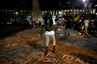 <p>An activist adds to a growing memorial of names written on the sidewalk outside the Omni Hotel as residents and activists march nearby amid heavy police and North Carolina National Guard presence as they protest the death of Keith Scott September 23, 2016 in Charlotte, North Carolina. Scott, 43, was shot and killed by police officers at an apartment complex near UNC Charlotte. Protests continue for a fourth night in Charlotte. (Brian Blanco/Getty Images)</p>